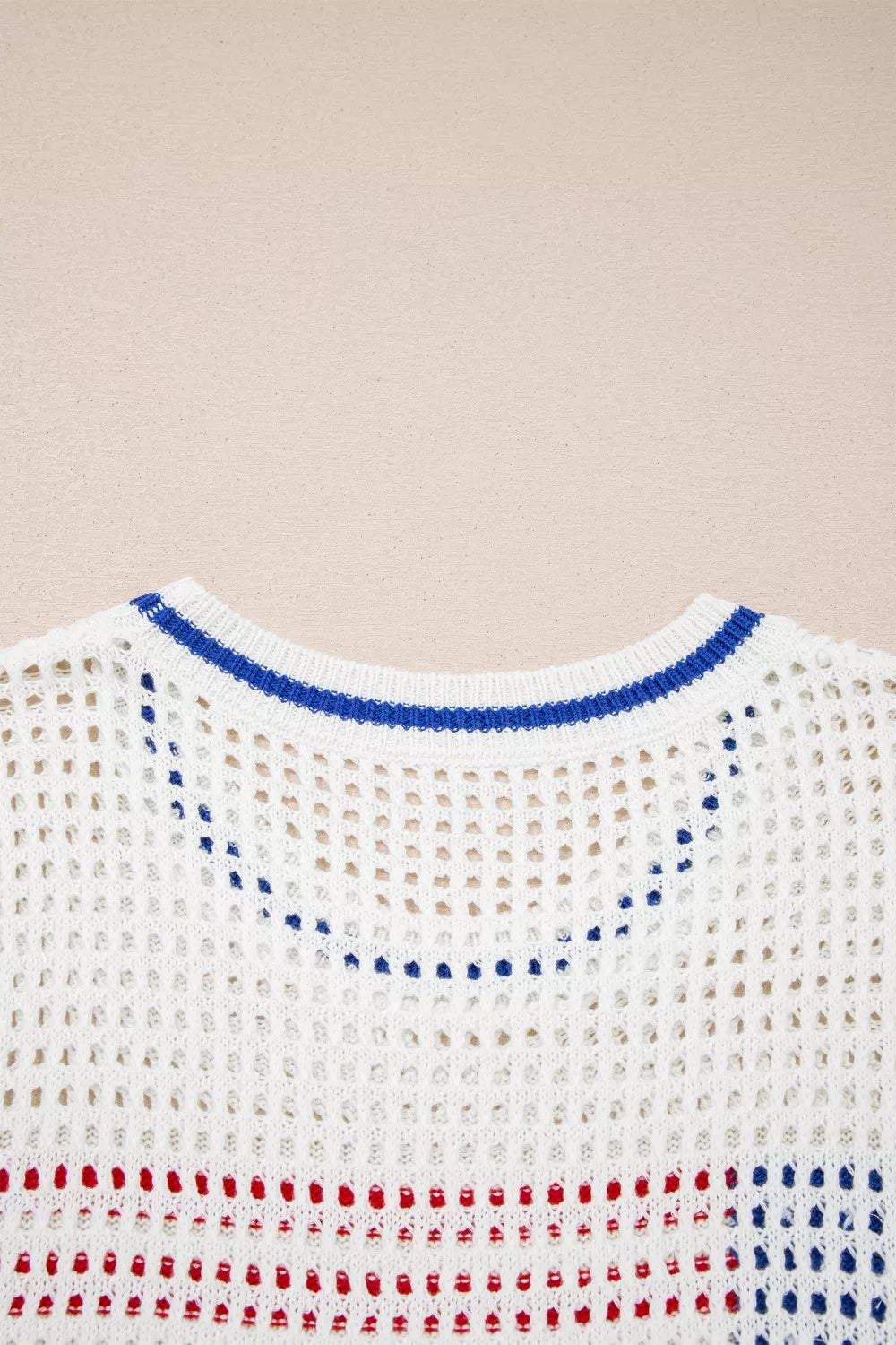 White eyelet knit sweater with blue neckline trim and red/blue stripes.