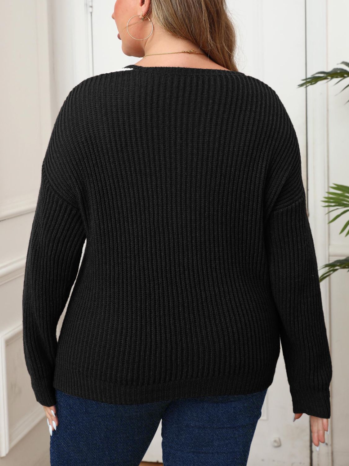 Black ribbed knit sweater with V-neck and contrast trim detail