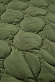 Moss green quilted sleeveless jacket detail showing diamond stitching pattern