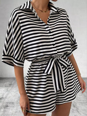 Black and white striped belted romper with collared button-front top and short sleeves.
