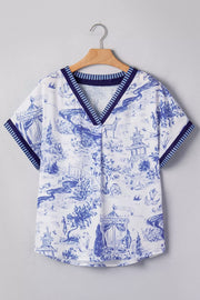 White and blue toile print v-neck blouse with striped accents and short sleeves.