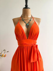 Orange tiered maxi dress with plunging V-neck, halter straps, and cinched waist tie.