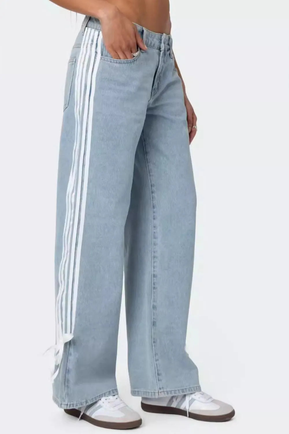 Light blue denim wide-leg trousers with white side stripes and tie detail at hem.