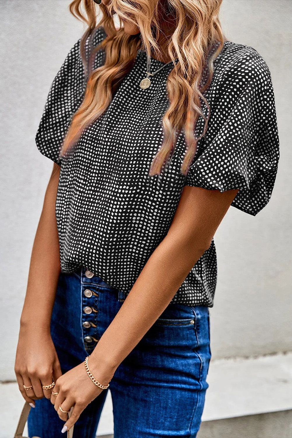 Black dotted puff sleeve blouse with round neckline.