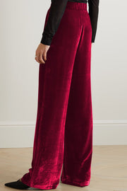 Burgundy velvet palazzo trousers with high waist and wide leg, styled with black pointed shoes.