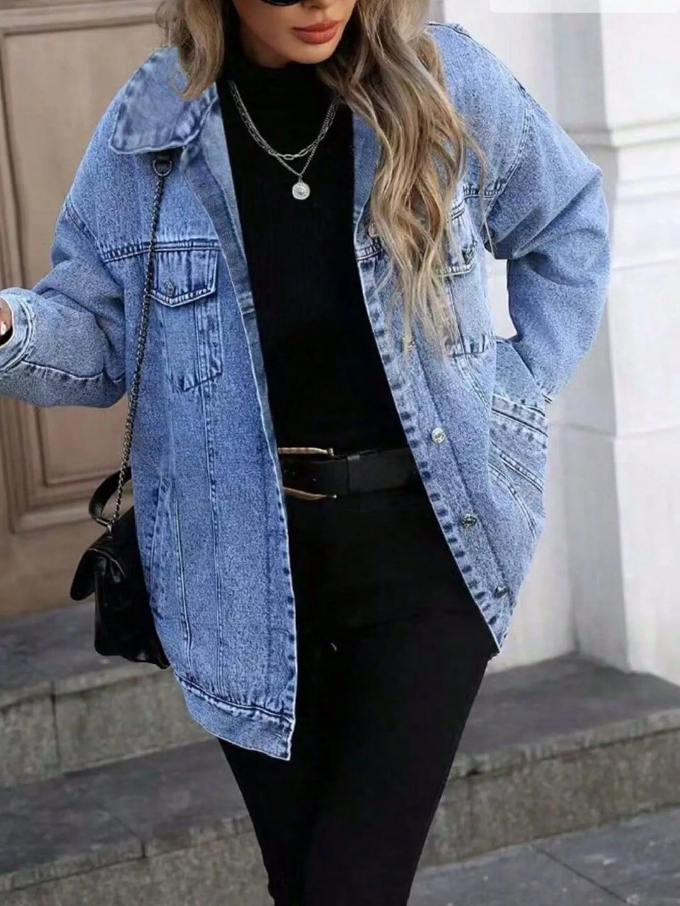 Oversized blue washed denim jacket with button front and chest pockets.