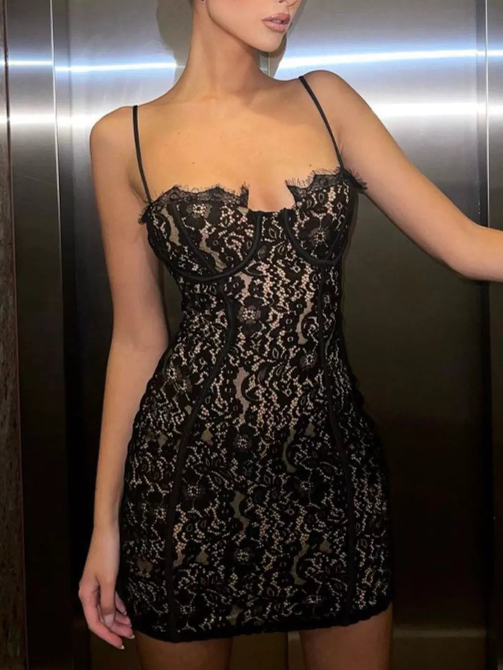 Black lace mini dress with spaghetti straps and scalloped neckline detail.