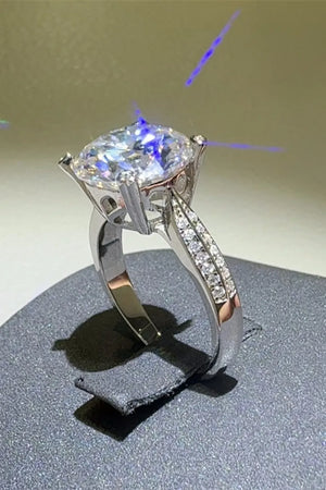 Silver pavé band round moissanite engagement ring with split shank and detailed stone setting.