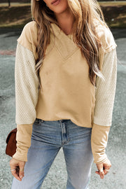Tan and cream colorblock hoodie with textured sleeves and v-neck.