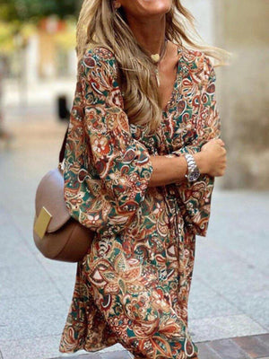 Paisley print balloon sleeve midi dress with V-neck and tie waist in red and brown tones.