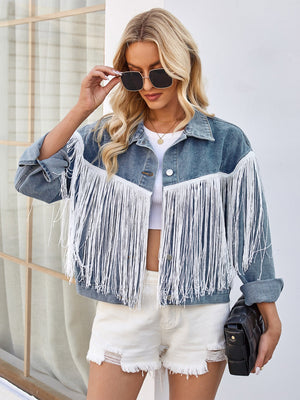 Denim trucker jacket in medium wash with white fringe trim and a boxy cut.