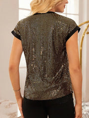 Gold sequin cap sleeve blouse with black trim, styled with black pants.