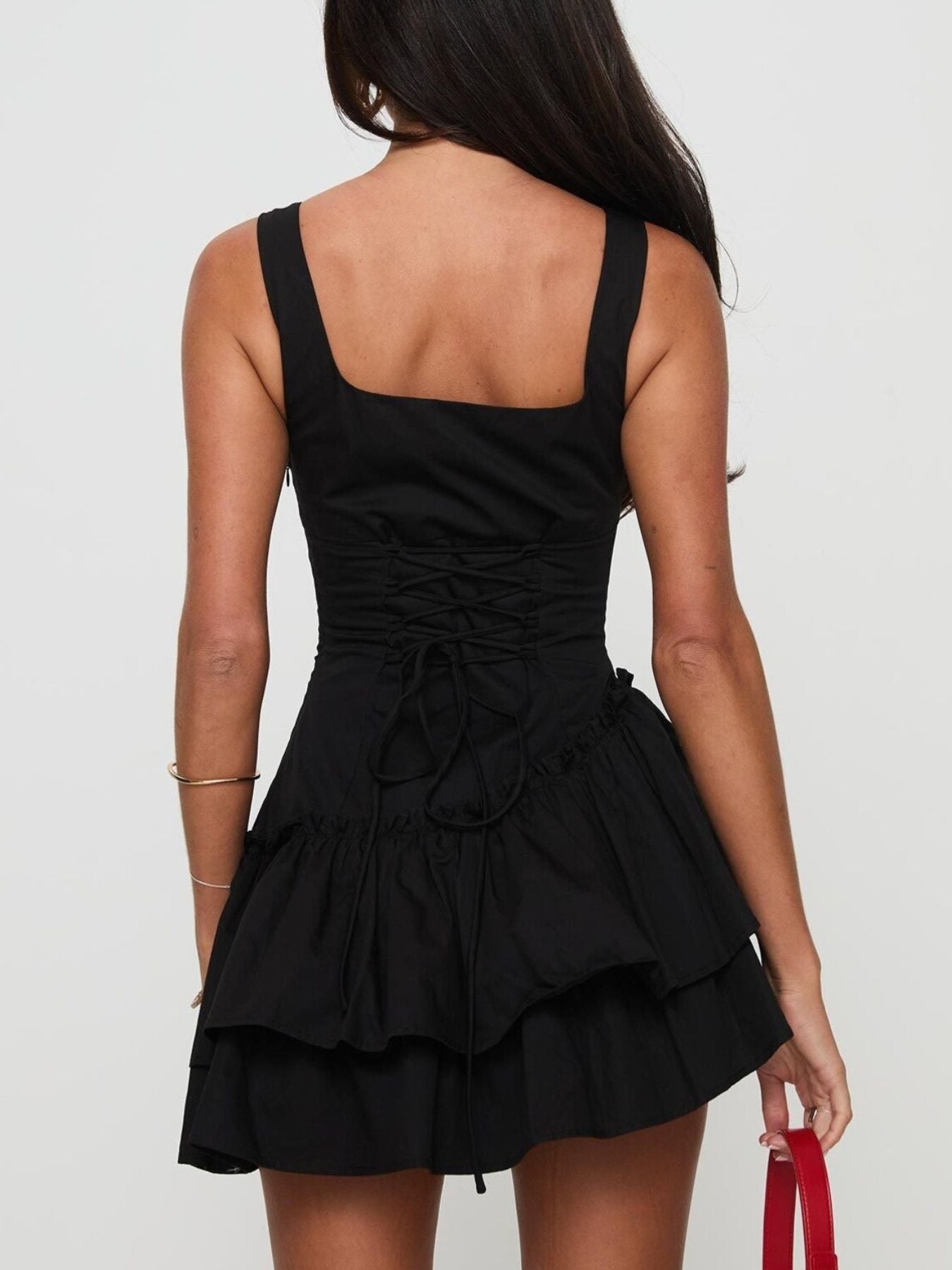 Black mini dress with square neckline, lace-up back, and tiered ruffled skirt.