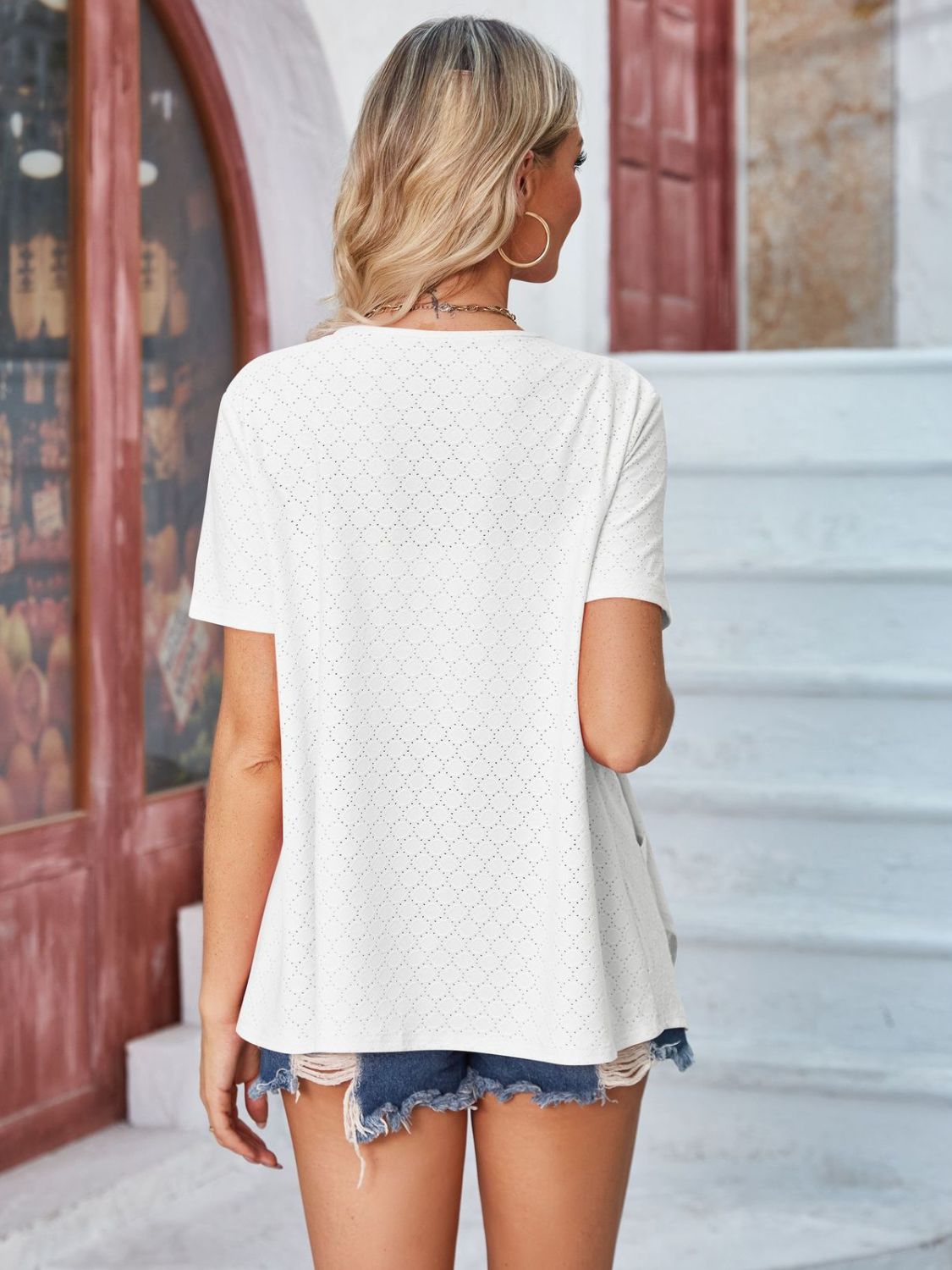 White perforated shawl collar jacket with short sleeves and a relaxed fit.