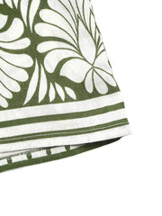 Botanical print halter neck jumpsuit in white with green leaves and striped hem.