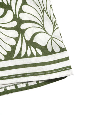 Botanical print halter neck jumpsuit in white with green leaves and striped hem.