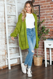 Open-knit slouchy cardigan in matcha green with open weave details and wide sleeves.