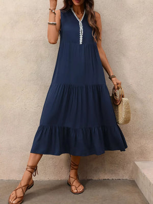 Navy midi dress with tiered ruffled hem and white embroidered neckline detail.