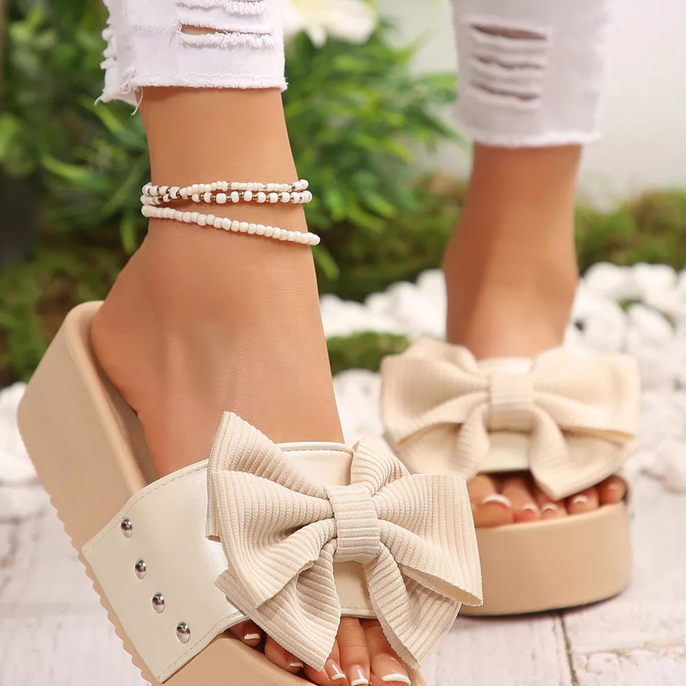 Ribbed bow accent platform sandals in white with chunky sole and studded strap detail.
