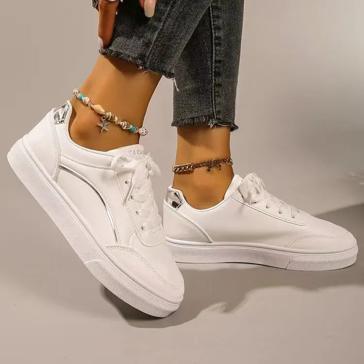 White sneakers with metallic silver trim and laces.