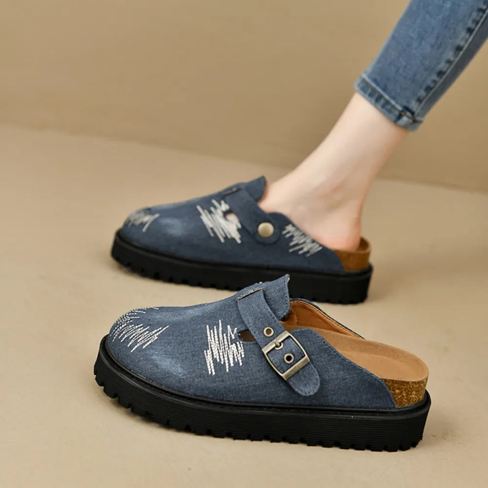 Embroidered denim platform clogs in medium blue with buckle detail and cork sole.