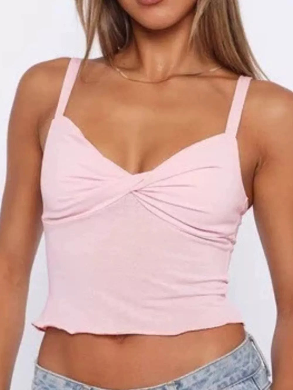 Pink cami top with twisted front detail and lettuce hem.