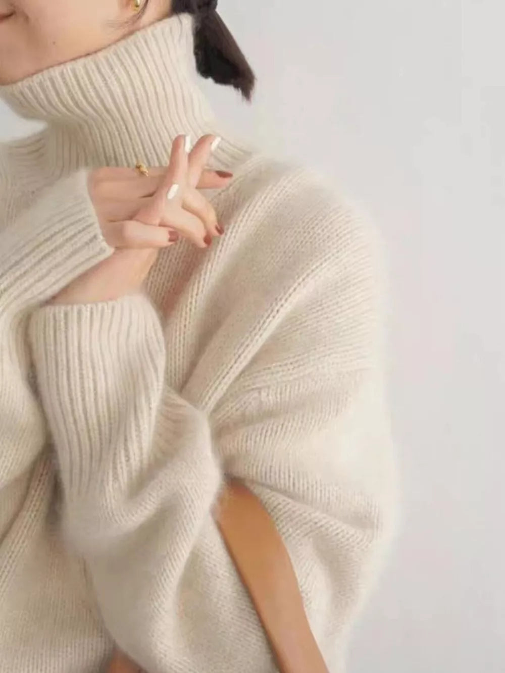 Cozy cream turtleneck knit sweater with dropped shoulders and ribbed texture.
