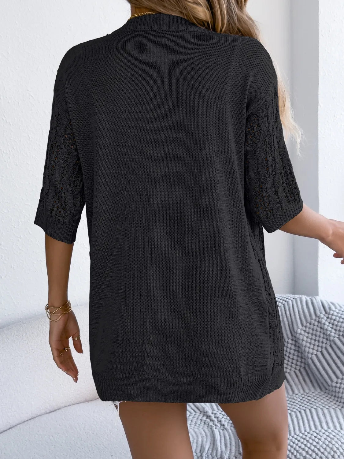 Black open-knit three-quarter sleeve cardigan with cable-knit detail on sleeves