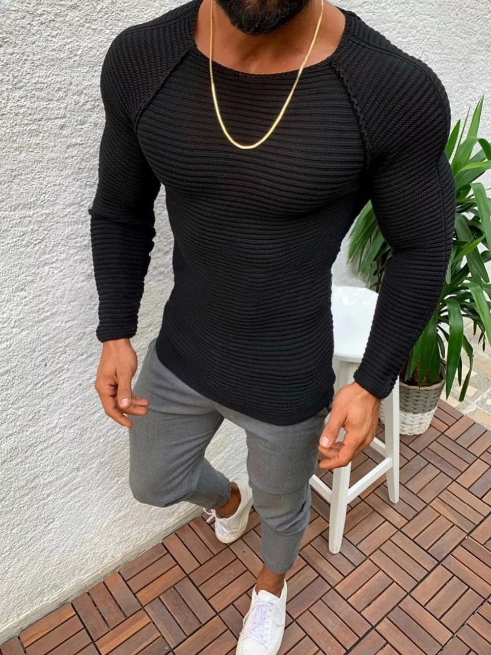 Black ribbed knit long sleeve sweater with crew neck and raglan sleeves.