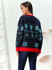 Dark blue acrylic cardigan with snowflake intarsia pattern and red trim.