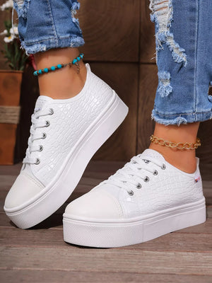 White crocodile embossed platform sneakers with chunky soles.