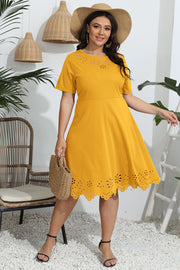 Mustard yellow midi dress with laser cutout details on neckline and hem.