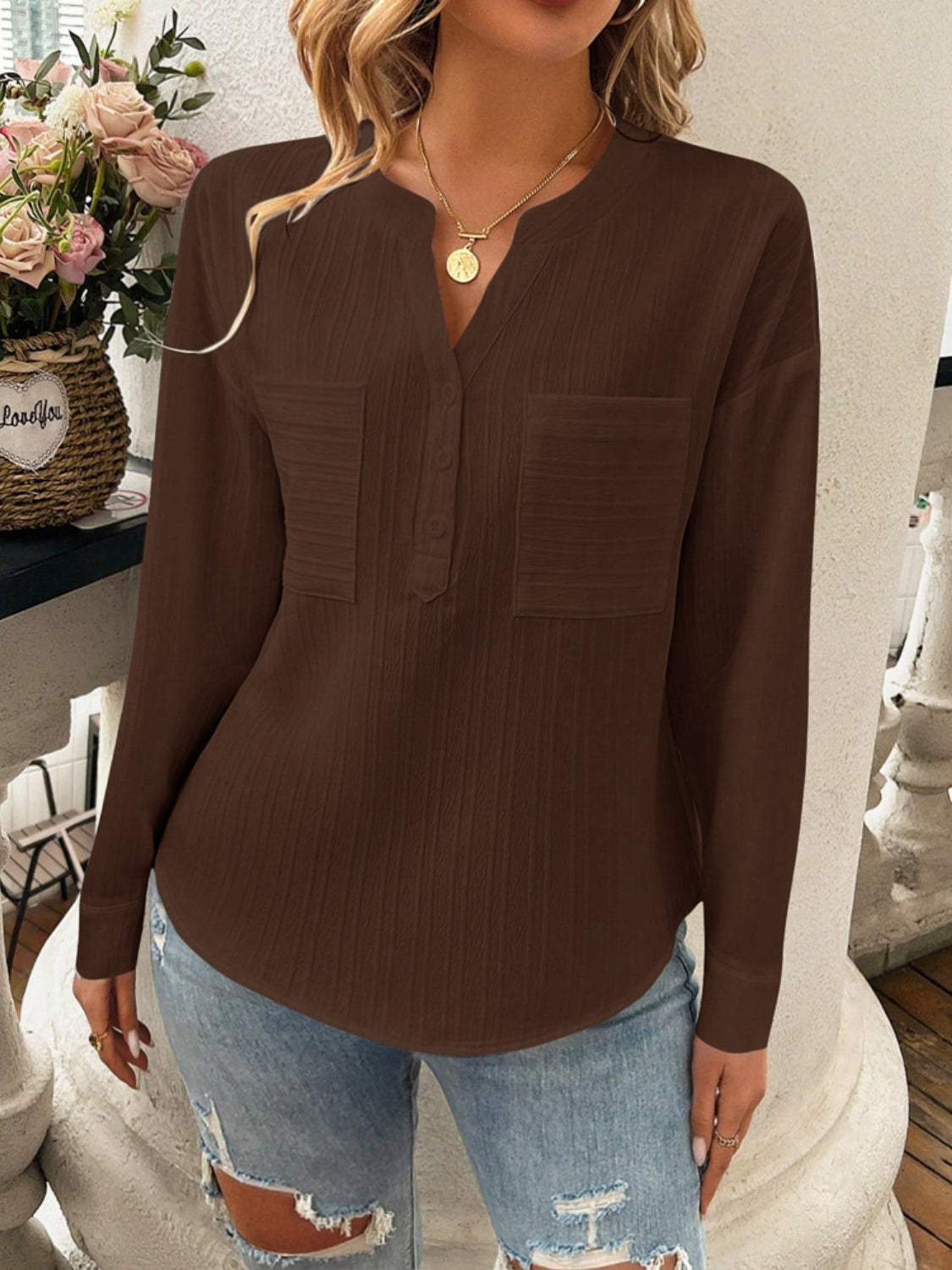 Chocolate textured henley blouse with two chest pockets and a V-neck.