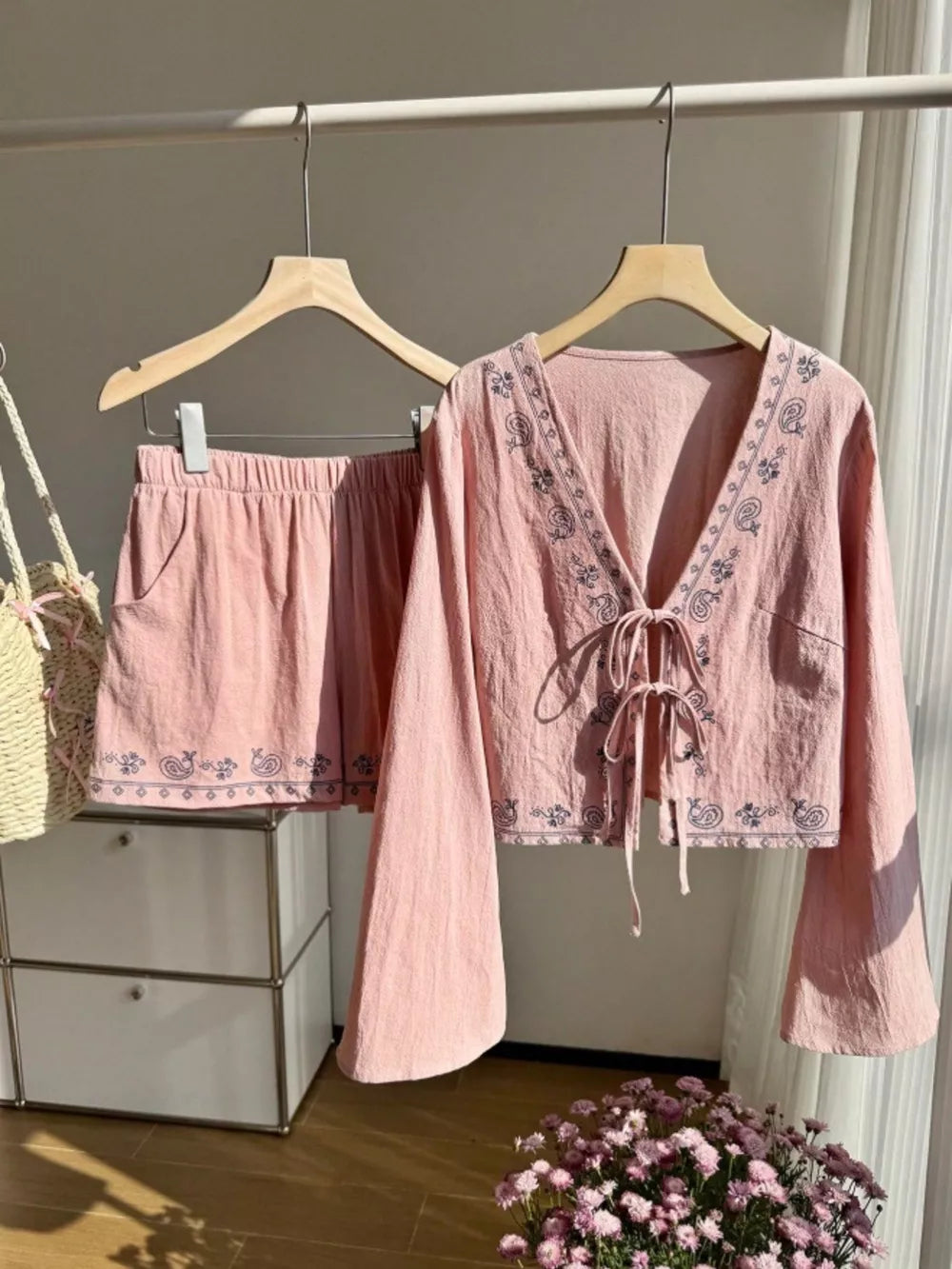 Pink embroidered tie-front top and shorts set with bell sleeves and elastic waist shorts.