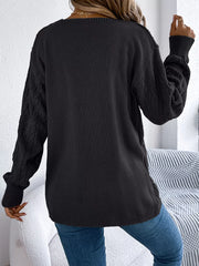 Black acrylic openwork cable knit cardigan with long sleeves.