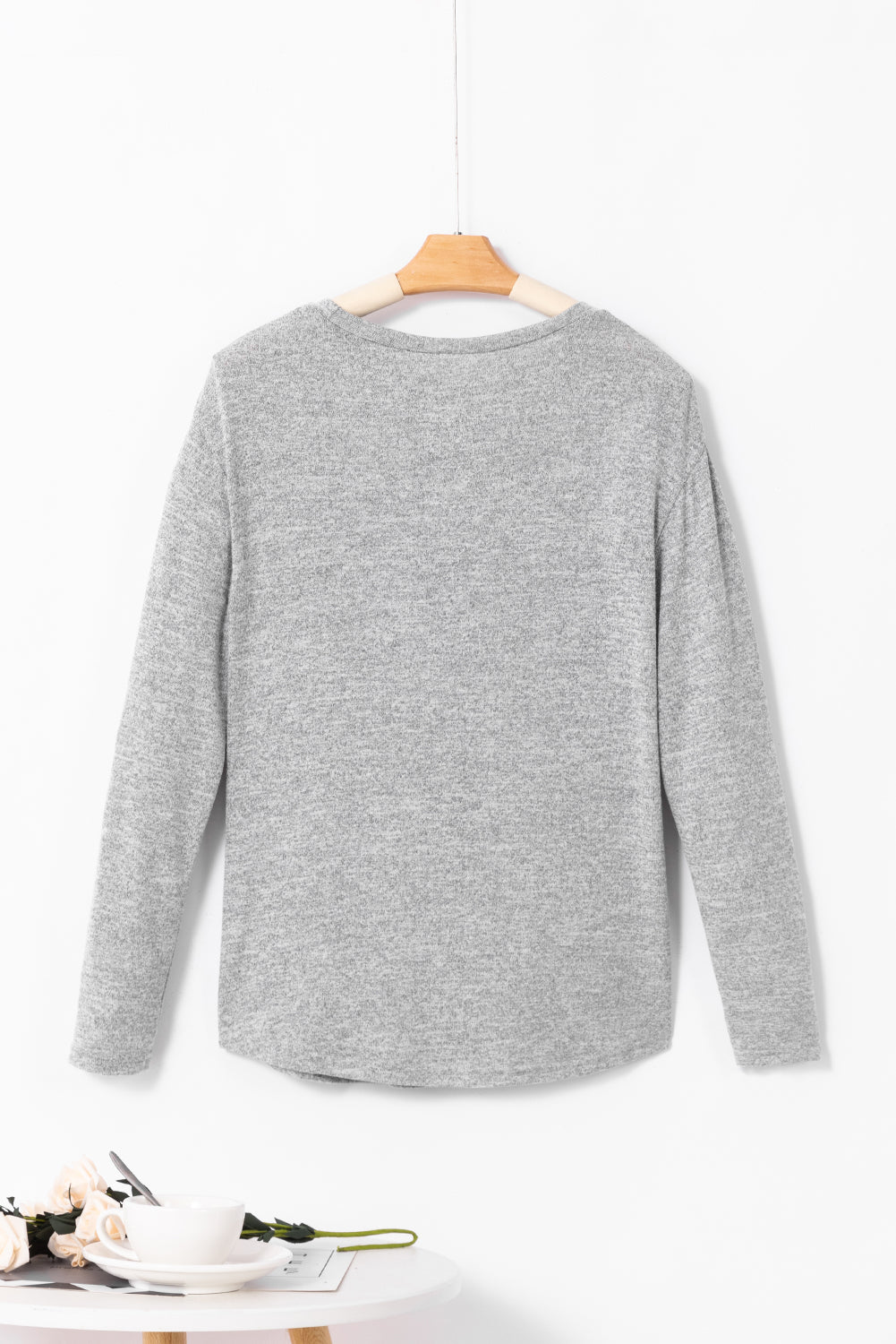 Dark gray slouchy knit top with side button detail and long sleeves.