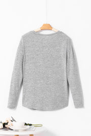 Dark gray slouchy knit top with side button detail and long sleeves.