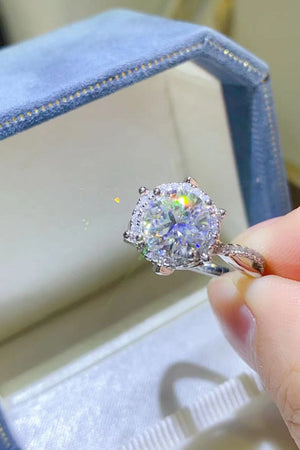 Silver moissanite engagement ring with halo and pave band.