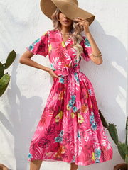 Hot pink tropical pleated midi dress with belt and short sleeves.
