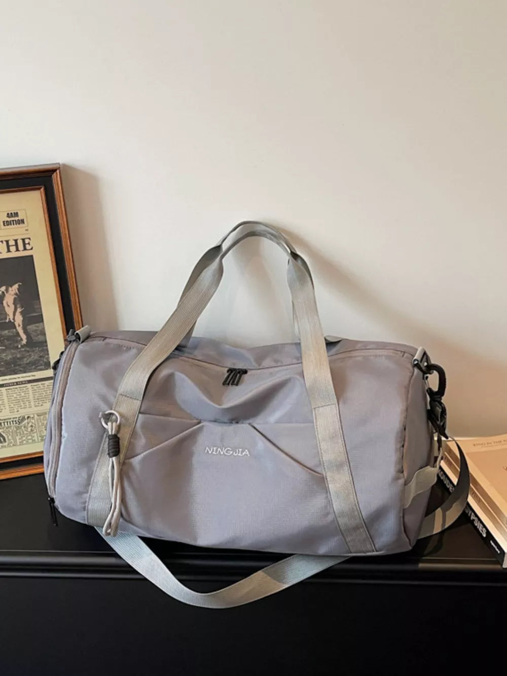 Premium large nylon travel duffle bag in dark gray with front pockets and dual straps.