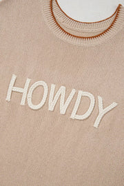 Howdy textured knit sweater vest in beige with braided white lettering and brown trim neckline.
