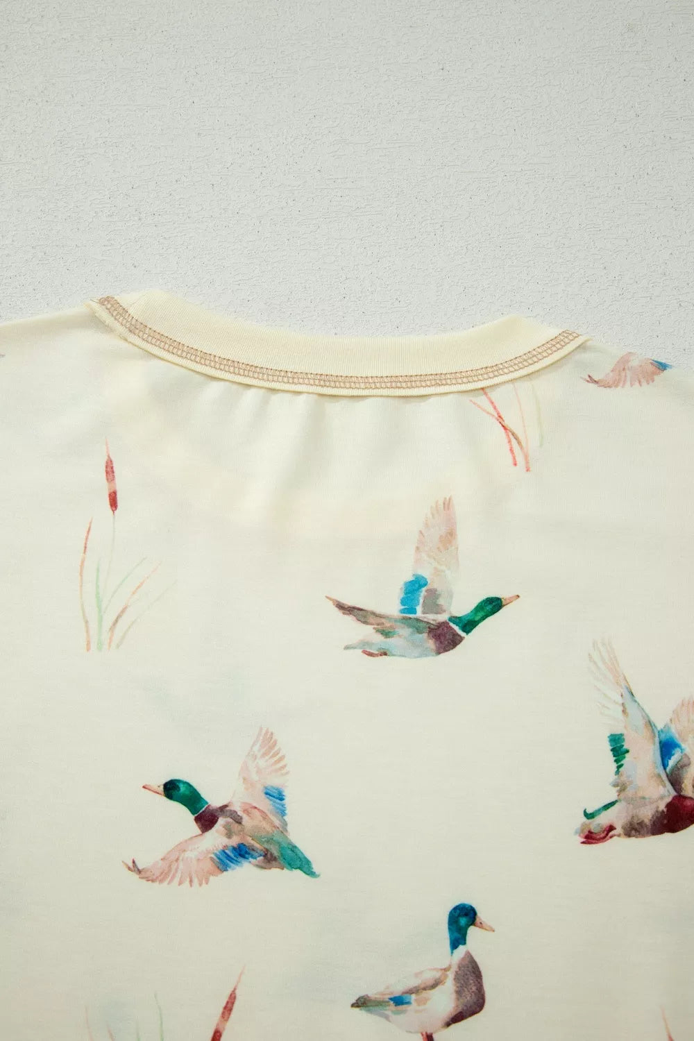 Beige crew neck pajama top with a mallard duck print and contrast stitching.