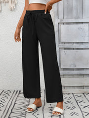Black drawstring wide-leg pants with pockets and a relaxed fit.