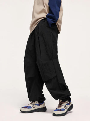 Black cargo joggers with drawstring waist and elastic cuffs, shown on a man.
