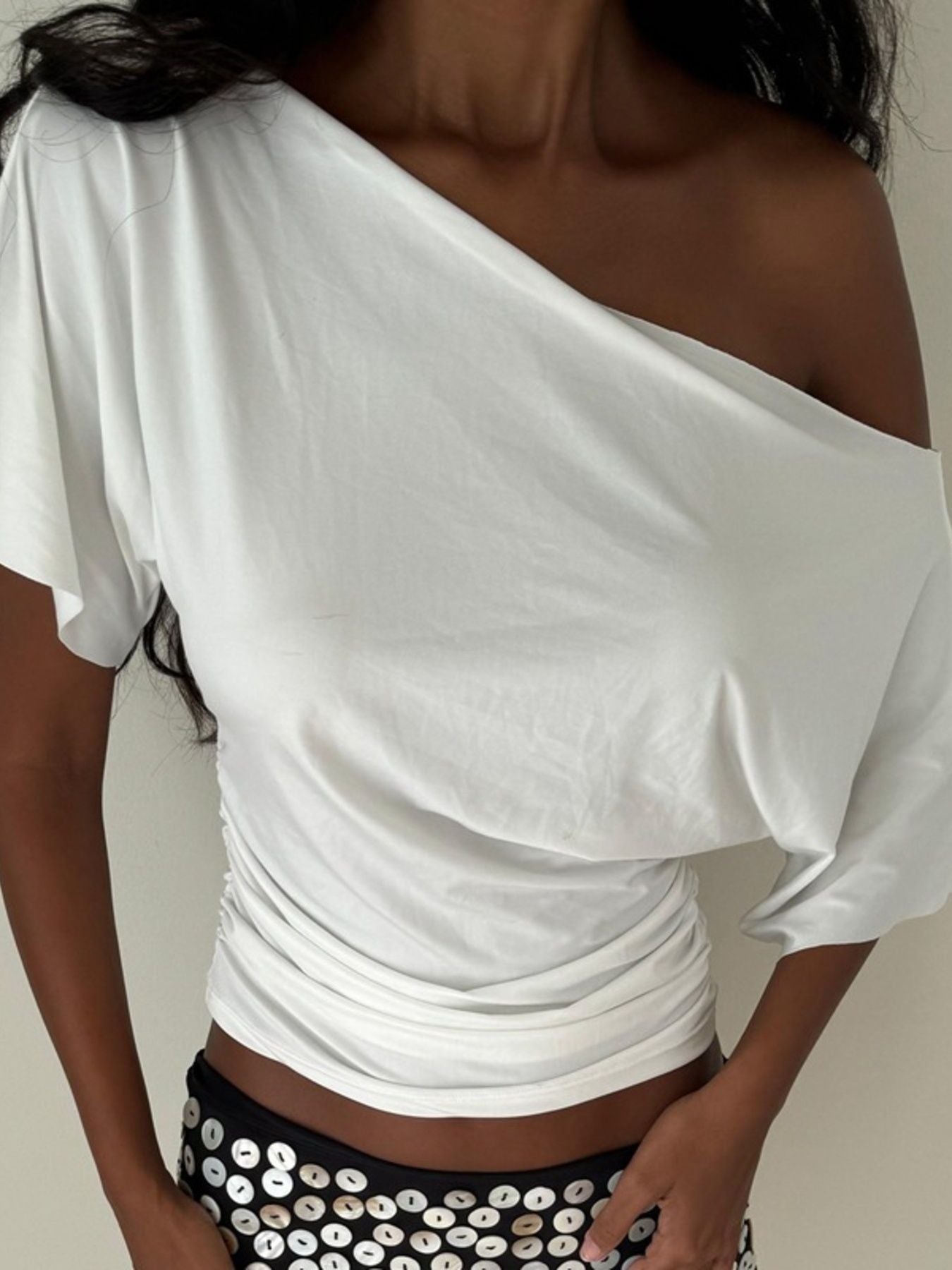 White ruched one shoulder t-shirt with asymmetrical neckline and dolman sleeves.