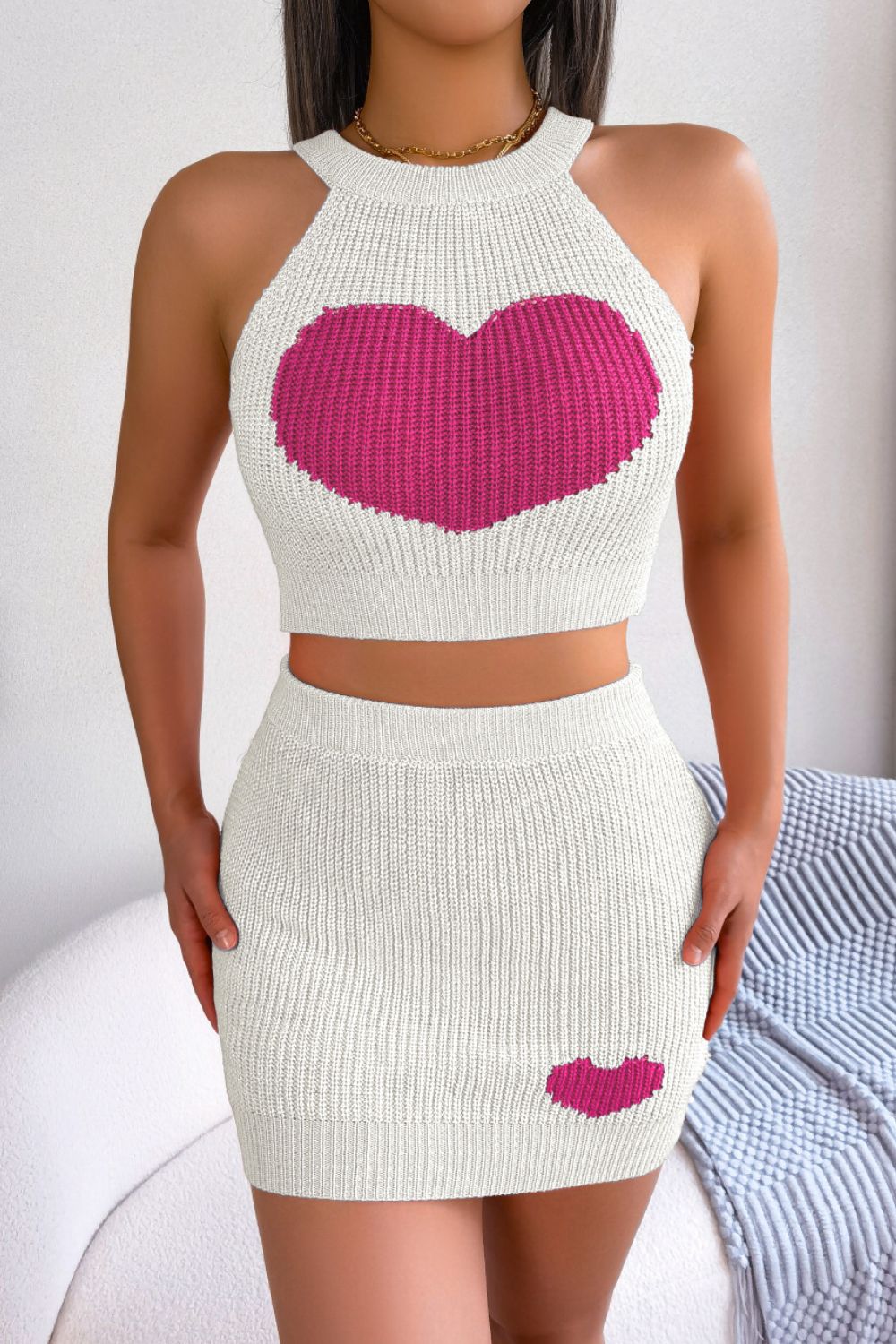 White knit halter crop top with large pink heart and matching mini skirt with small heart detail.