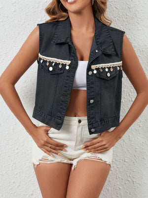 Black denim vest with cropped length, button-up front, chest pockets, and decorative trim with shells.