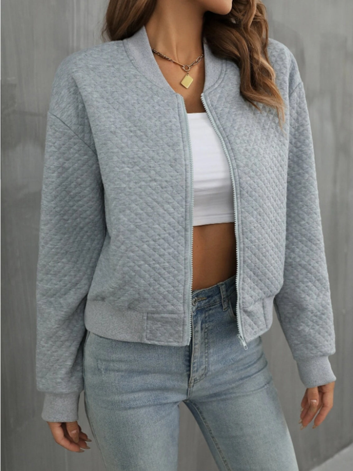 Gray diamond quilted bomber jacket with zipper and ribbed cuffs.