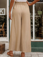 Tan textured wide-leg drawstring trousers with a comfortable elastic waistband.