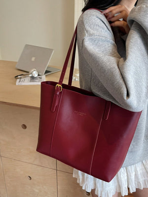 Wine red structured pu leather tote bag with gold buckle detail and shoulder straps.